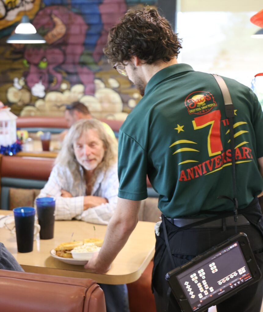 Jacob at Jacks serving a customer with a 7 year anniversary shirt on
