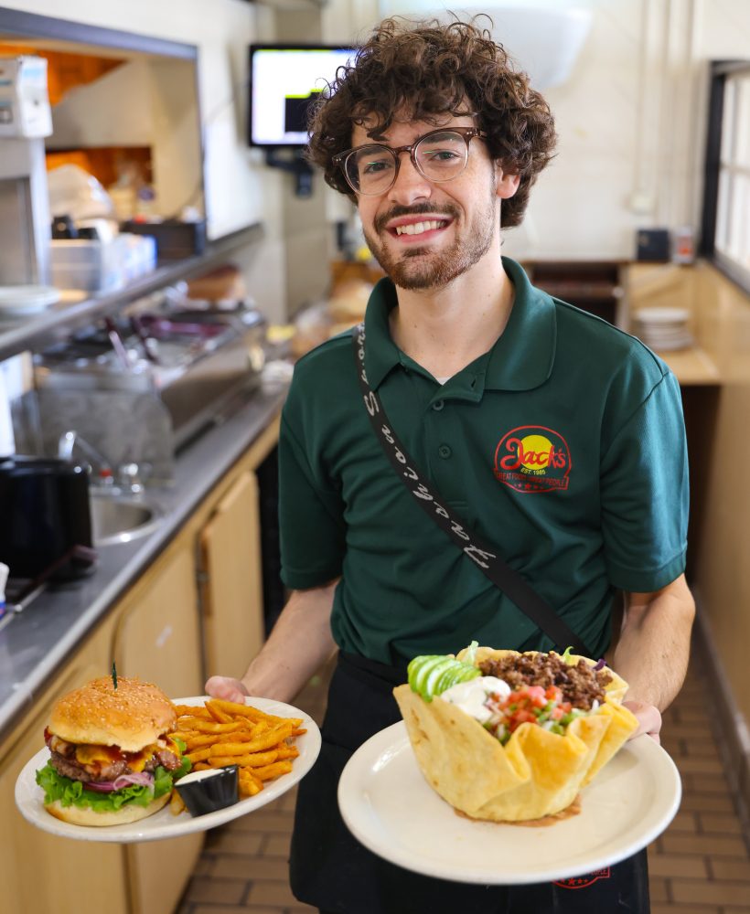 Jacob at Jack's holding a cheeseburger and a taco salad